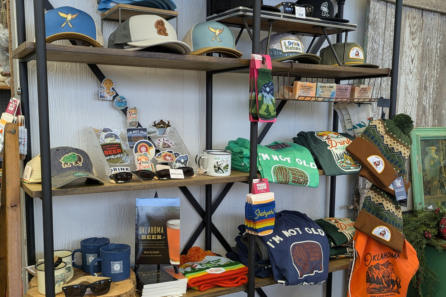 Display of various hats, bags, and clothing items on shelves in a store.